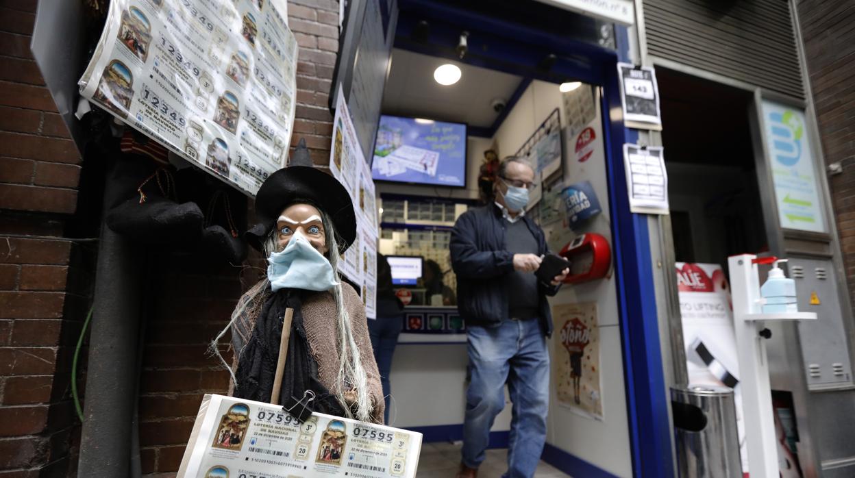 Imagen de una administración de lotería donde un ciudadano compra su décimo de Lotería de Navidad