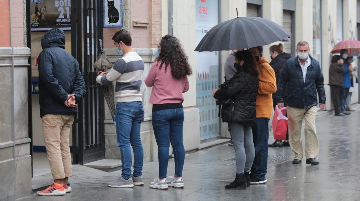 Colas para comprar décimos de la Lotería de Navidad en una administración de Sevilla