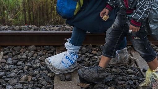 Una mujer y un niño llegan a Hungría caminando por la vía del tren desde Serbia