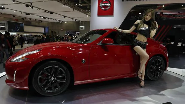 Una modelo posa junto al nuevo modelo 370Z de la marca Nissan durante el Salón del Automóvil de Seúl