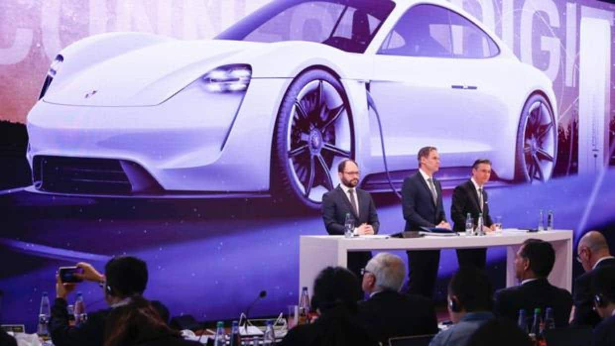 Oliver Blume, CEO de Porsche, Lutz Meschke, responsable de Finanzas, y Josef Arweck, vice presidente de Comunicación, ante una imagen de su prototipo eléctrico Mission E