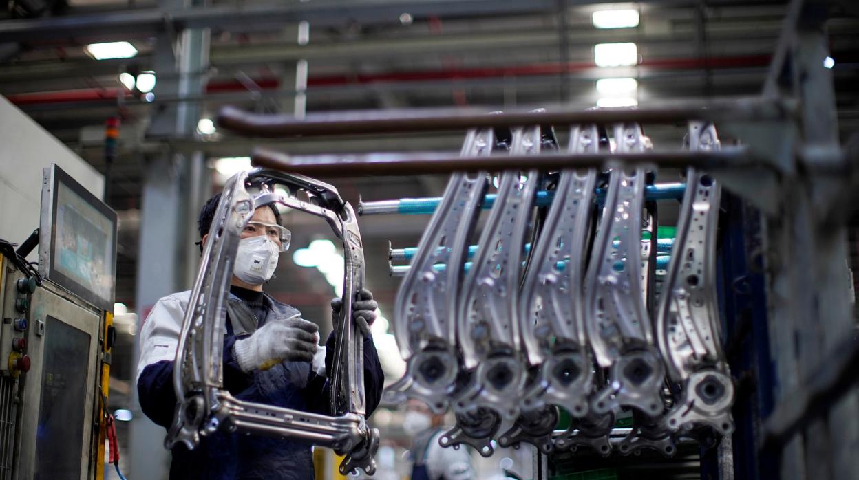 Empleado con mascarilla en una factoría de vehículos