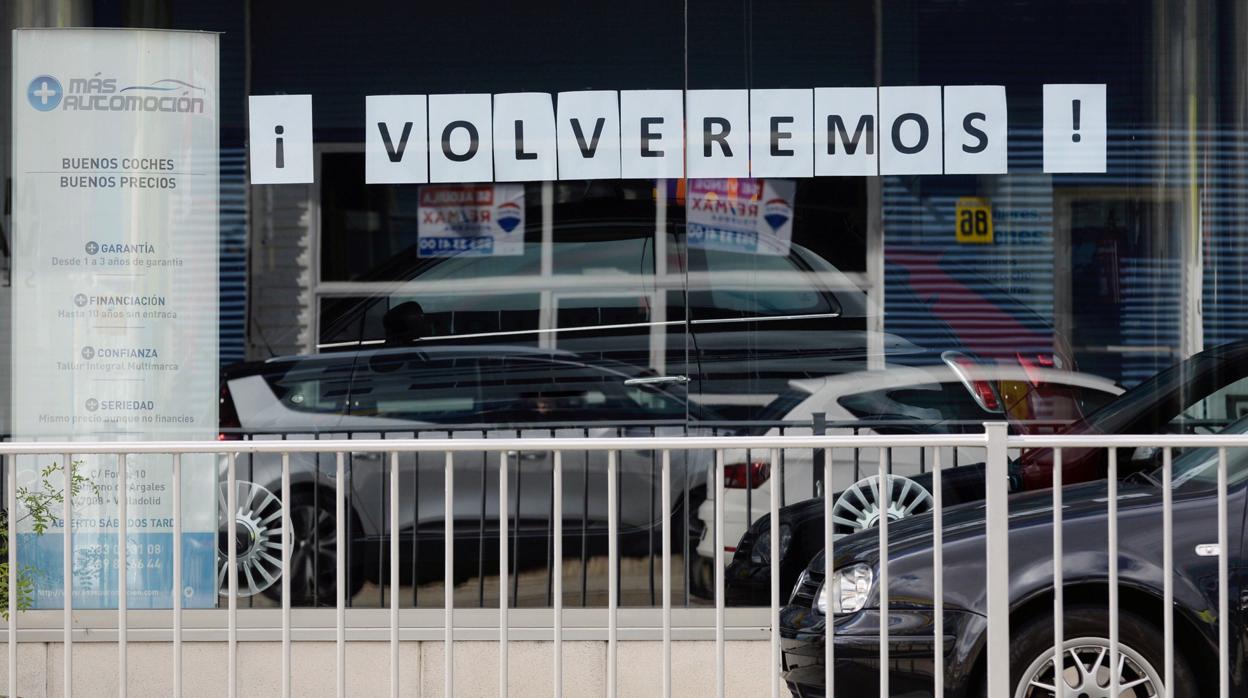 Un concesionario de Valladolid, cerrado por la pandemia, muestra un cartel de «Volveremos» en su escaparate