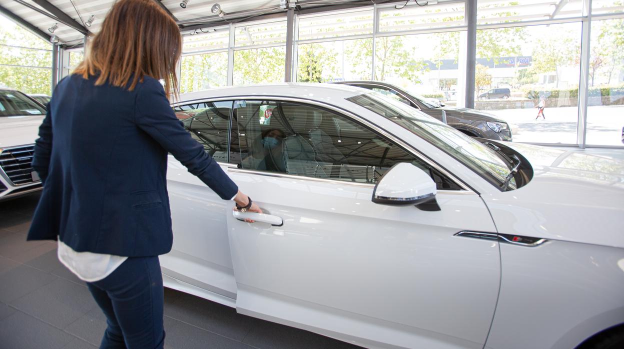 Una mujer abre un coche aparcado en el interior de uno de los concesionarios reabiertos en la Fase 1 de desescalada,