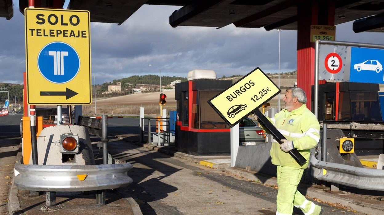 Un operario retira la señalización del peaje alavés de Armiñón de la autopista AP-1, en 2018