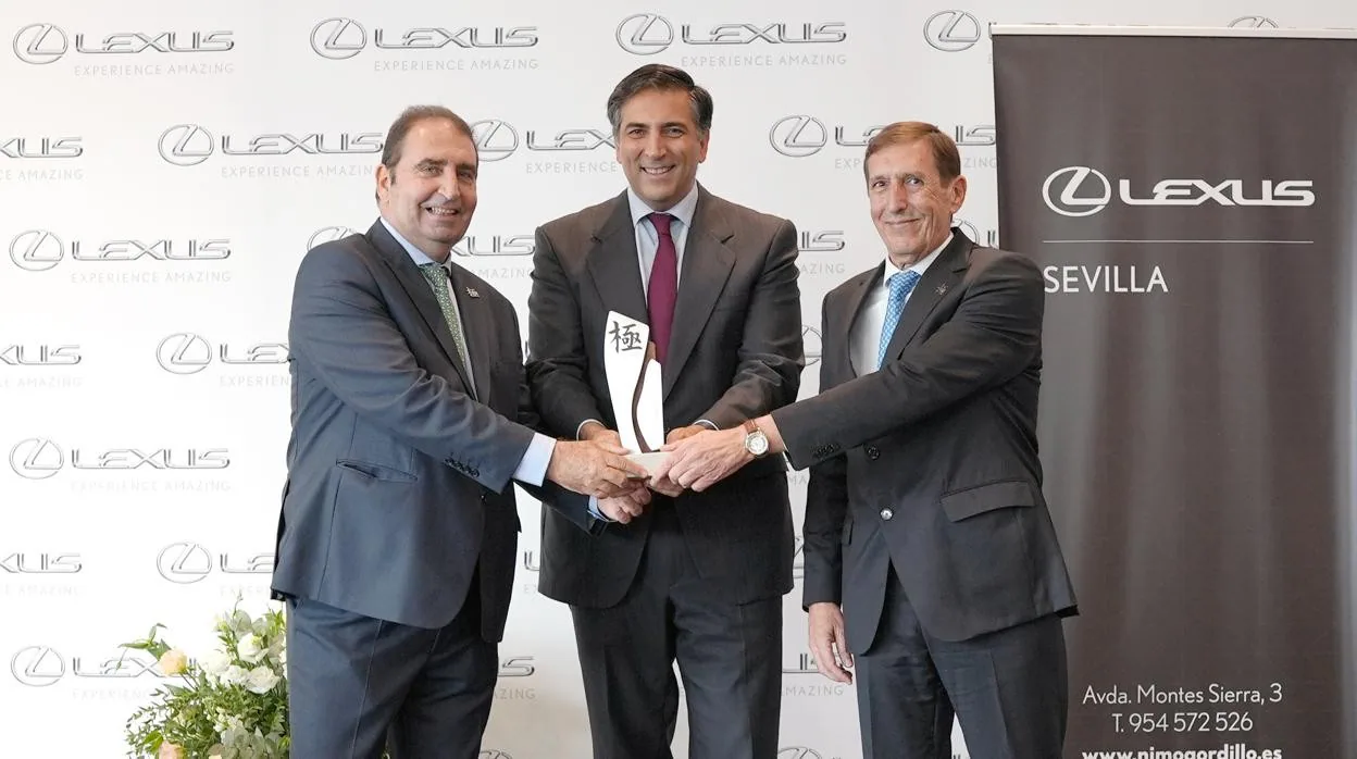 Miguel Carsi (c.) hace entrega del premio al consejero delegado de Lexus Sevilla, Ramón Nimo (i.), y a su director general, Joaquín Meseguer (d.)