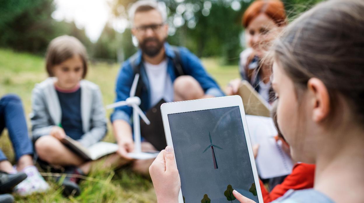 Un grupo de estudiantes con sus profesores da clases al exterior utilizando las nuevas tecnologías para abordar cuestiones ambientales