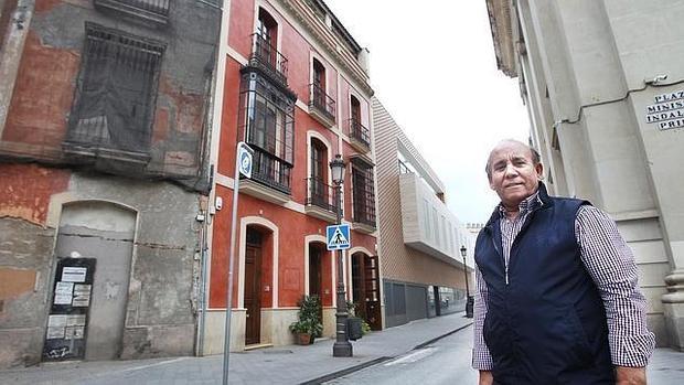 Juan Manuel Chacón, junto a su restaurante y el polémico edificio vanguardista al fondo