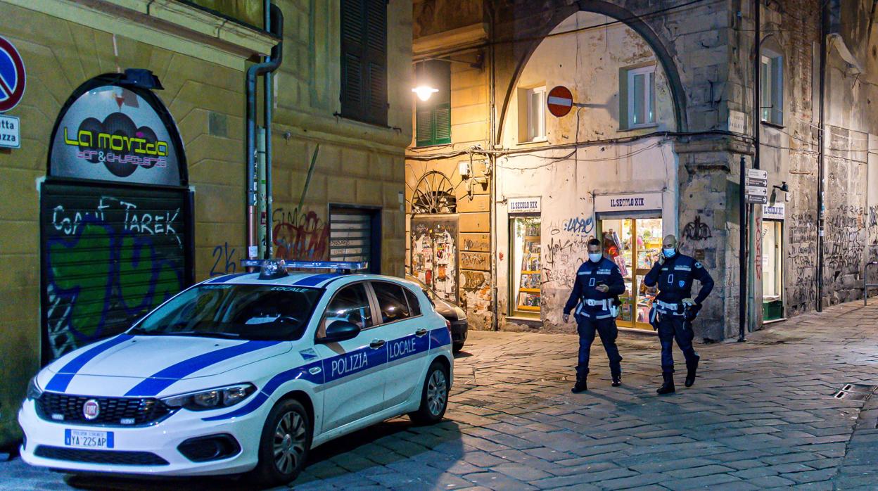 La policía italiana patrulla una calle desierta en el centro de la ciudad de Génova