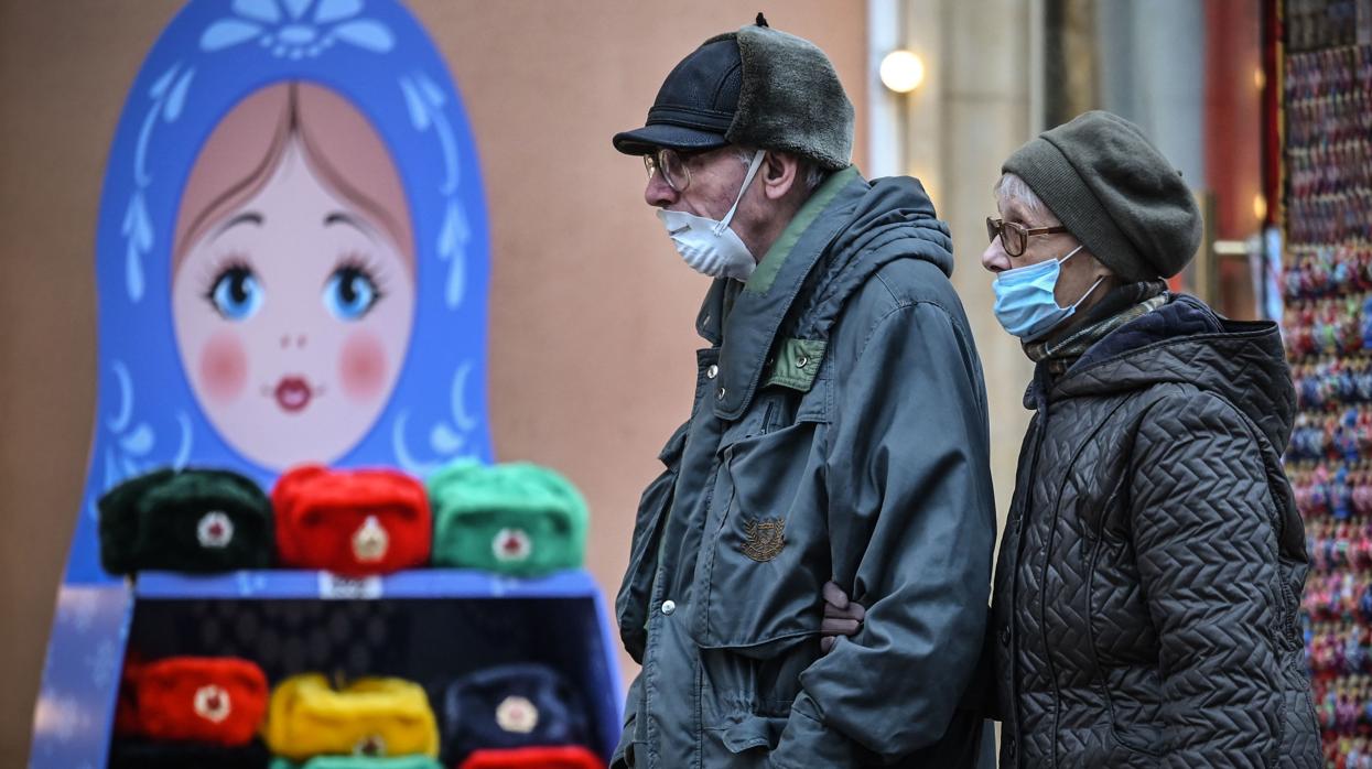 Una pareja paseando con mascarilla por las calles de Moscú/ La pandemia de coronavirus roza los 66 millones de contagios globales