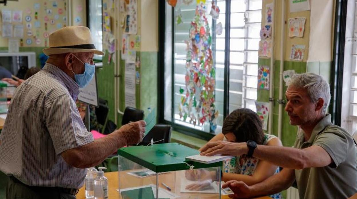 Un andaluz ejerce su derecho al voto en un colegio de primaria en el sevillano barrio de San José Obrero