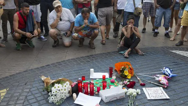 Varias personas se paran en el mosaico de Miró en las Ramblas de Barcelona después del atentado ocurrido este jueves