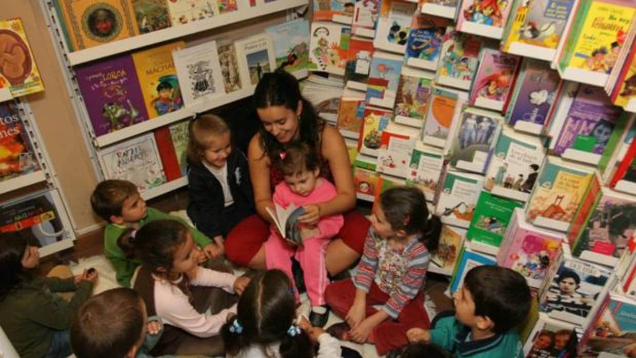 Una joven lee un cuento a un grupo de niños en una librería