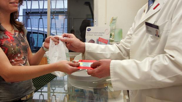 Una usuaria retira medicamentos en una farmacia andaluza