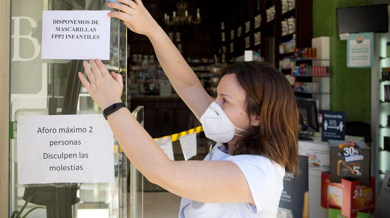 Una farmacéutica, con mascarilla.