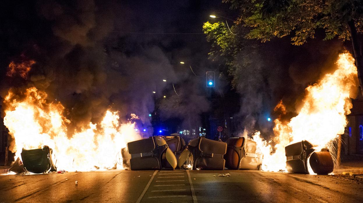 Varias personas queman contenedores en la protesta llevada a cabo por los CDR con motivo del tercer aniversario del 1-O, en Girona.