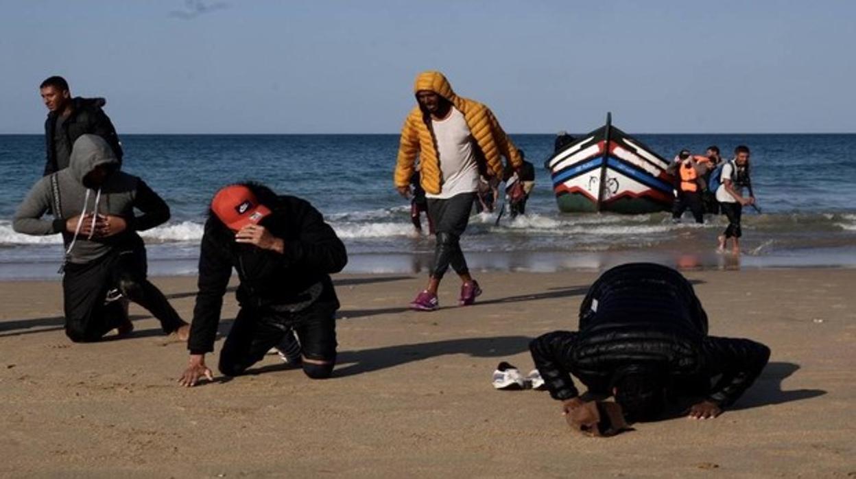 Inmigrantes besan la orilla al llegar a Cádiz.