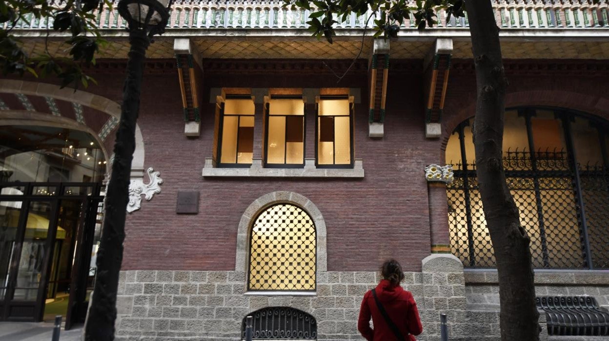 Una vecina de Barcelona observa ayer los daños causados por los vándalos en las ventanas del Palau de la Música