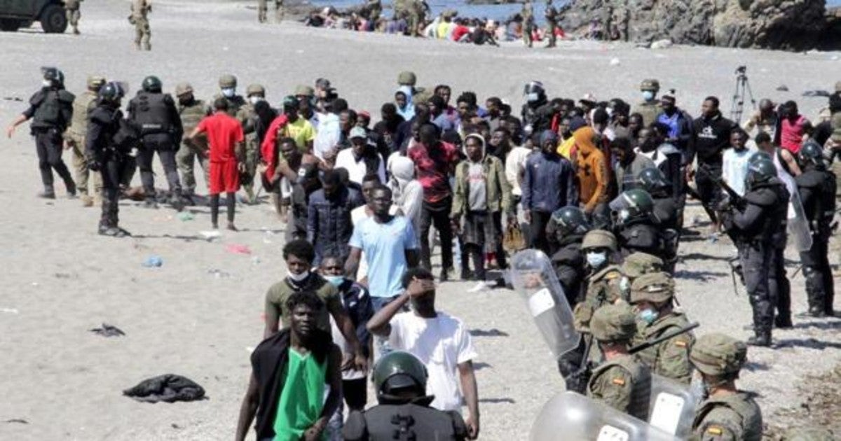 Soldados e inmigrantes en Ceuta.