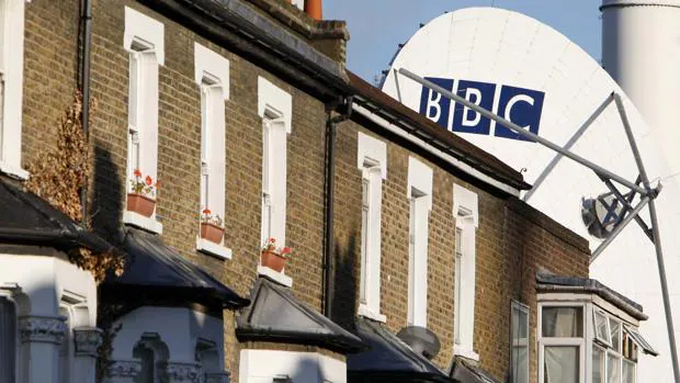 Una antena repetidora tras unas casas de un barrio residencial en Londres