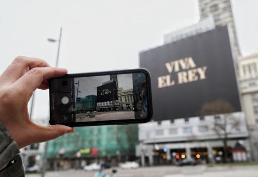 Imagen de una persona haciéndose un selfie frente al cartel de Amazon