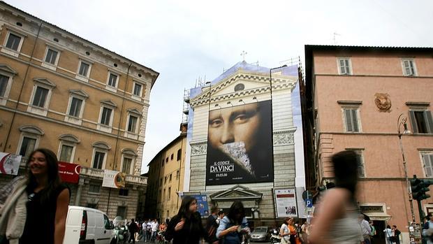 Obras en una iglesia romana cubiertas con una lona publicitaria