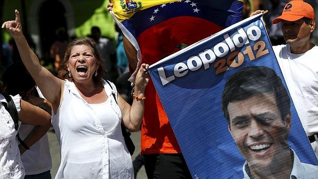 Una mujer, con un cartel electoral de Leopoldo López, hoy encarcelado