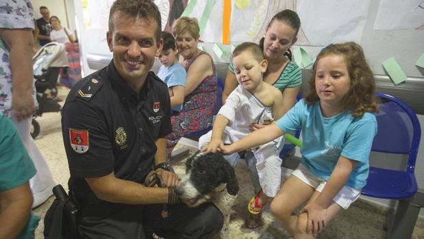 Un agente de la unidad enseña a los niños uno de los perros policías.