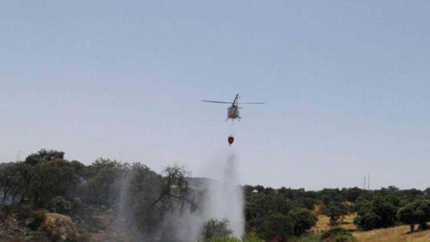 Un helicóperto apagando las llamas en el incendio