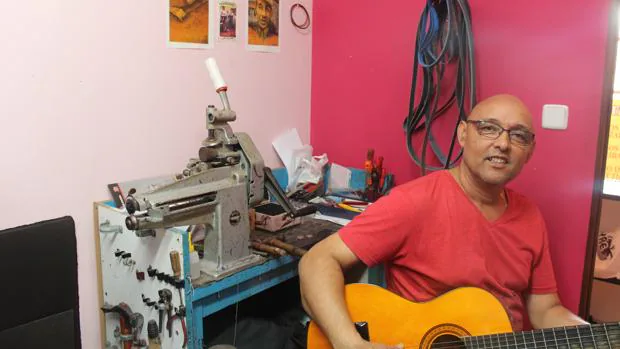 Ignacio Zambrana con su guitarra en su taller de zapatería