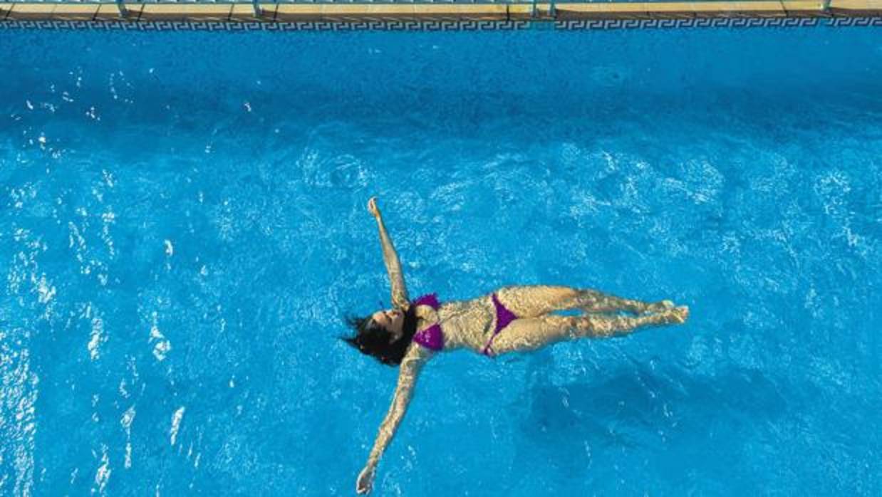 Una mujer se refresca en la piscina