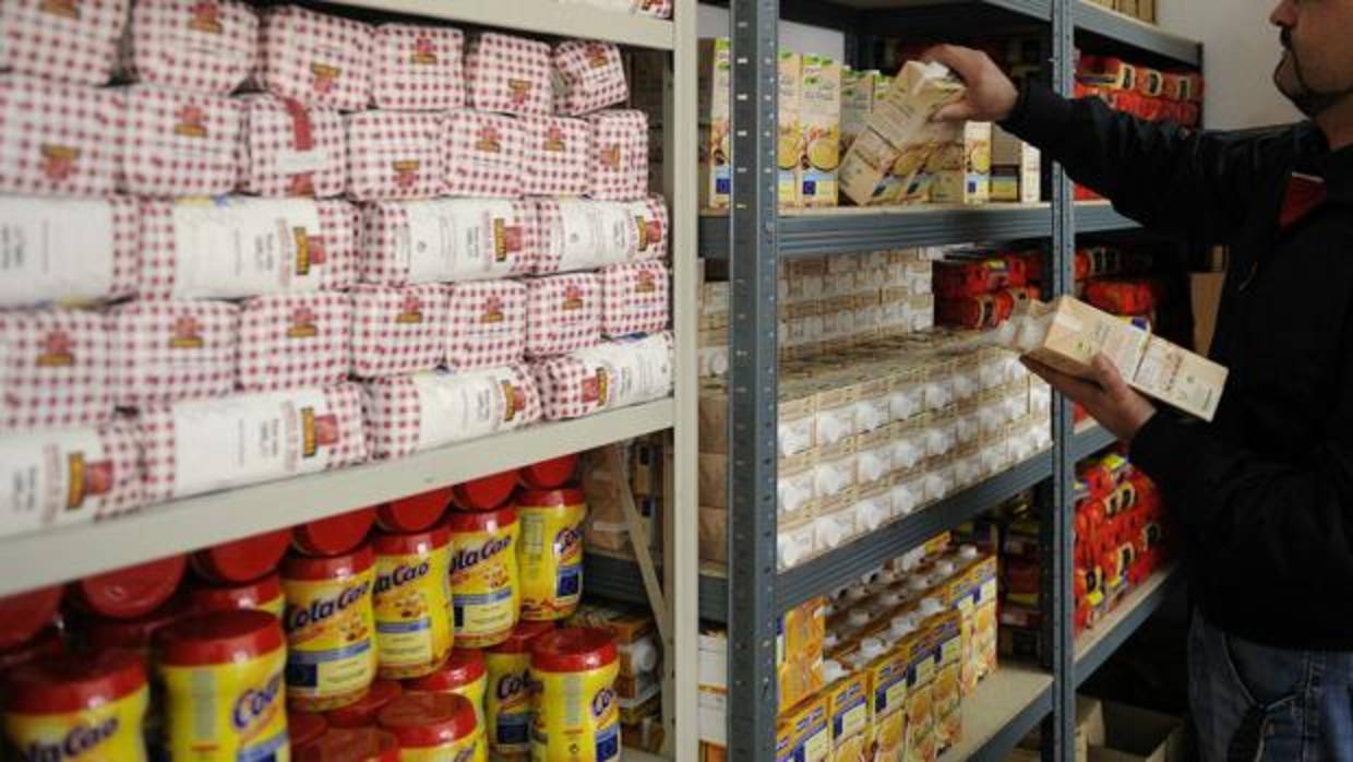 Voluntario coloca alimentos en las estanterías del almacén de un banco de alimentos