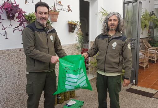 Dos agentes de la Junta depositan el cuerpo de la nutria en una bolsa