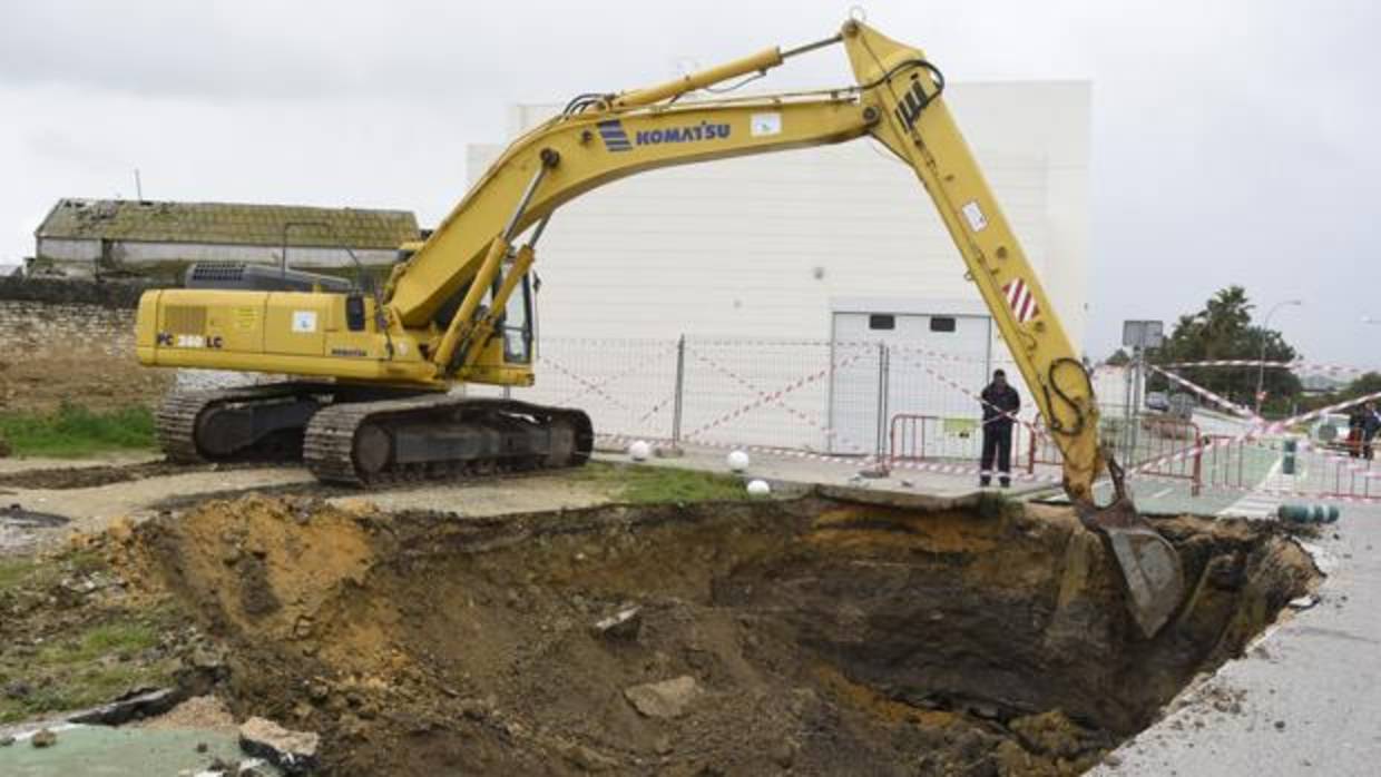 Una grúa trabaja en el socavón que se ha producido por las lluvias