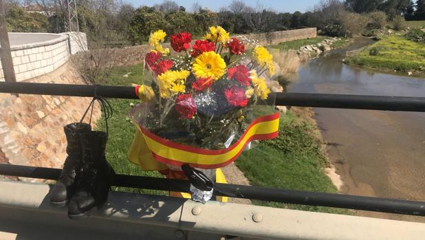 Unas botas, flores y bandera recuerdan al guardia civil en el arroyo donde murió