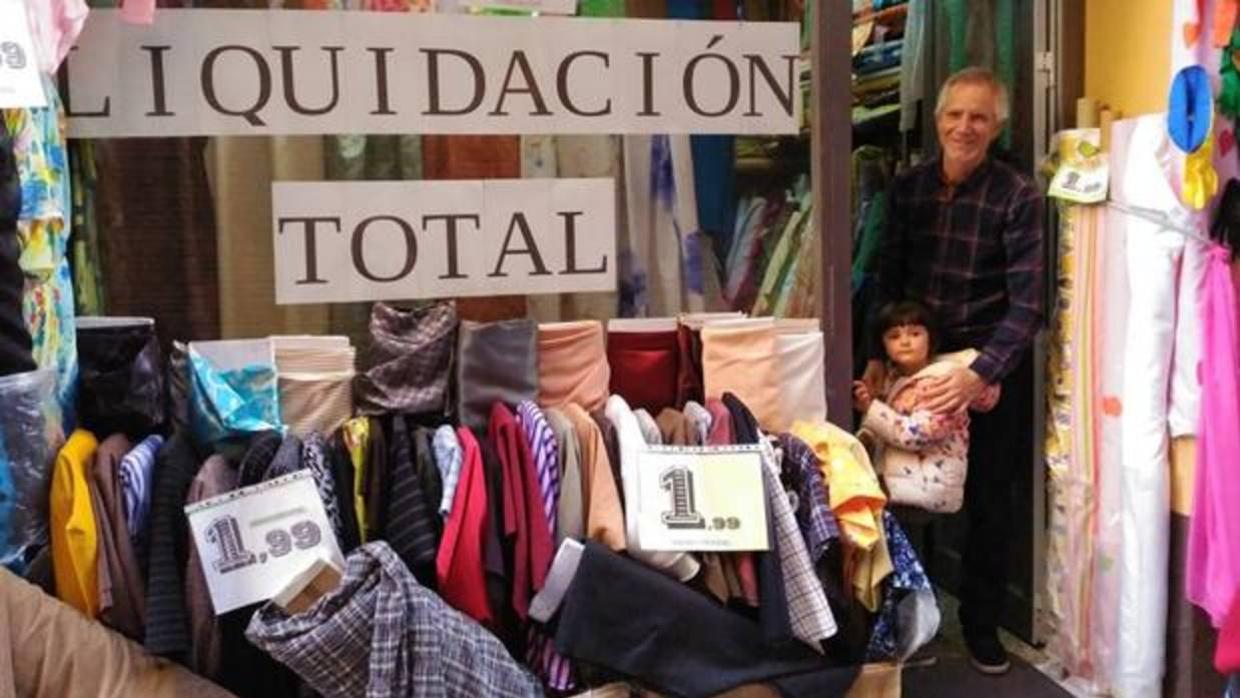 Rafael Castro, junto a su nieta, en la puerta de la tienda 'El Arcoiris'