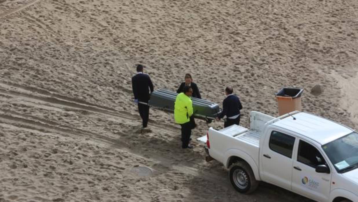 Momento en el que los servicios de emergencias trasladaban al fallecido desde la playa.