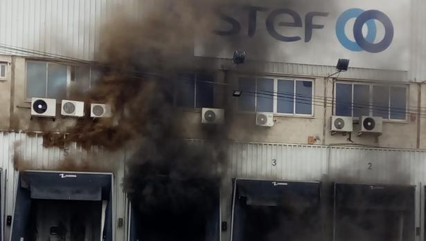 Espectacular incendio en una empresa de transporte de alimentación refrigerada en Sevilla