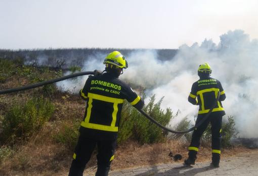 Bomberos sofocando el incendio en la zona de pasto