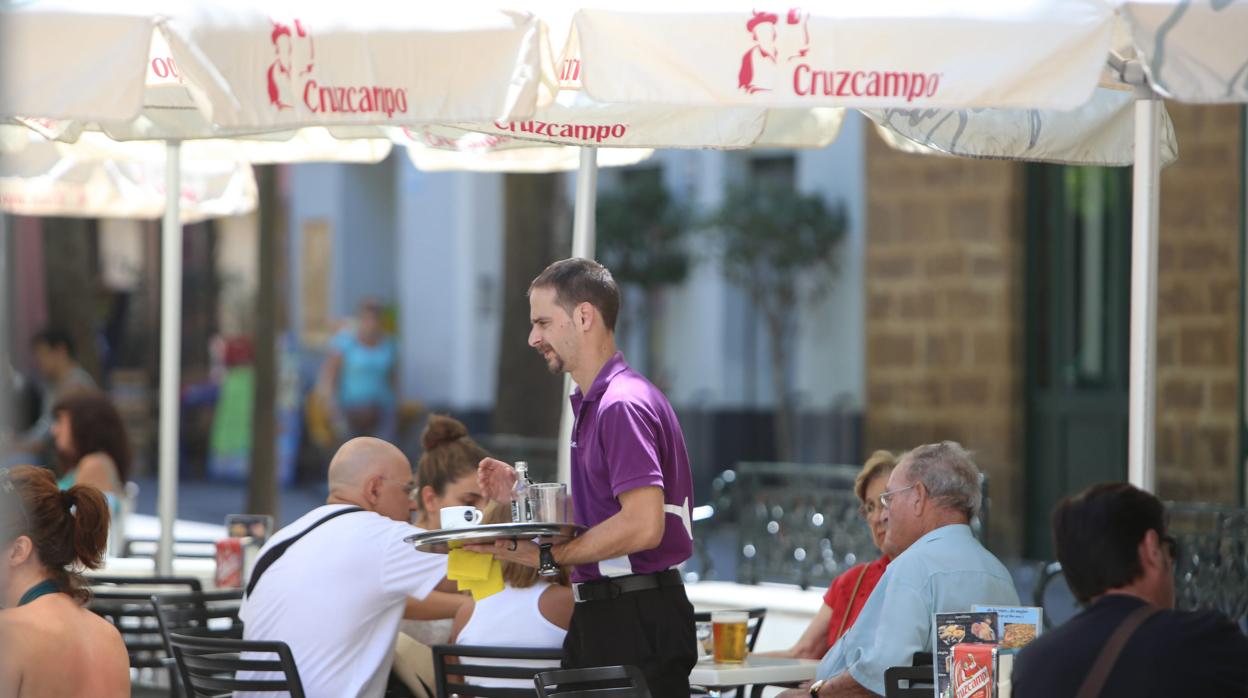 Un camarero presta sus servicios en una terraza de un bar de Cádiz