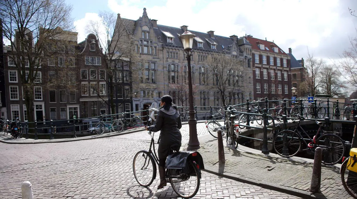 Una mujer circula en bicicleta por una calle de Amsterdam