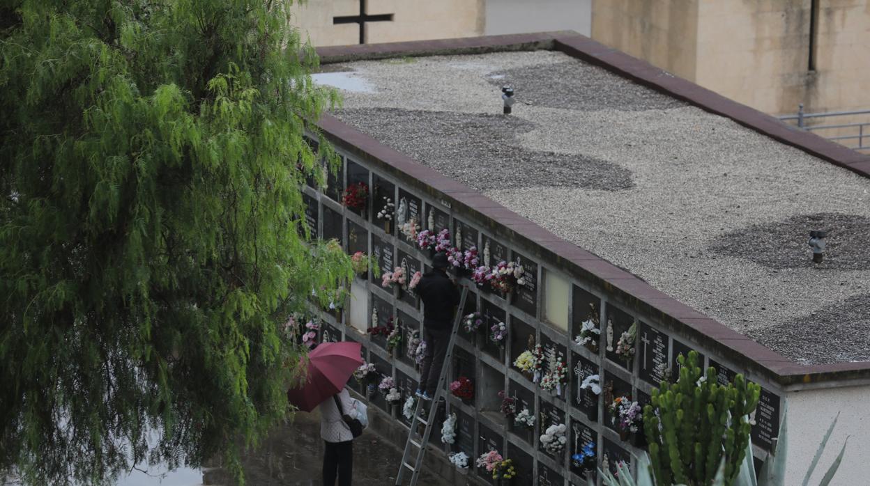 Una familia deposita flores en la tumba de un ser querido.