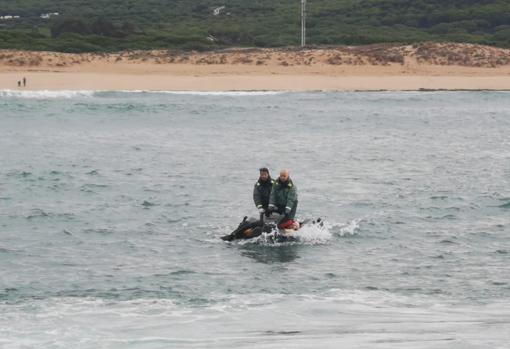 La Guardia Civil lleva hasta la orilla uno de los cadáveres.