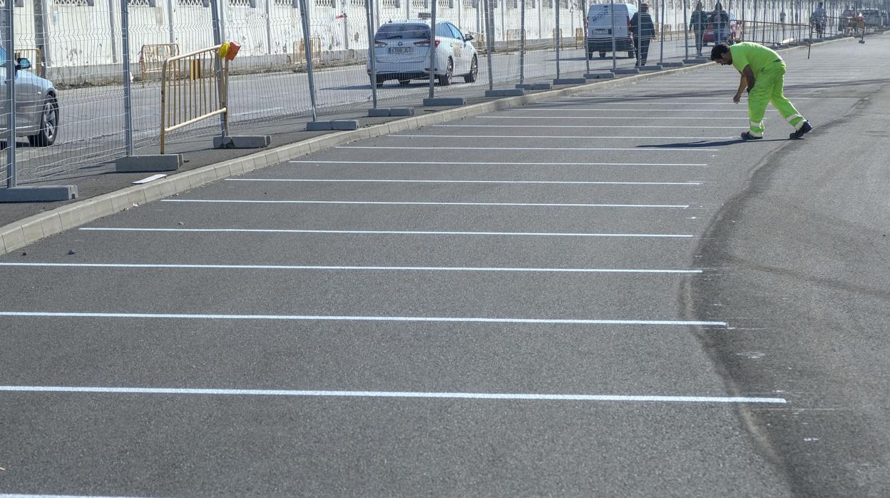 Operarios ultimando la puesta a punto del parking gratis al aire libre en la avenida de Astilleros.