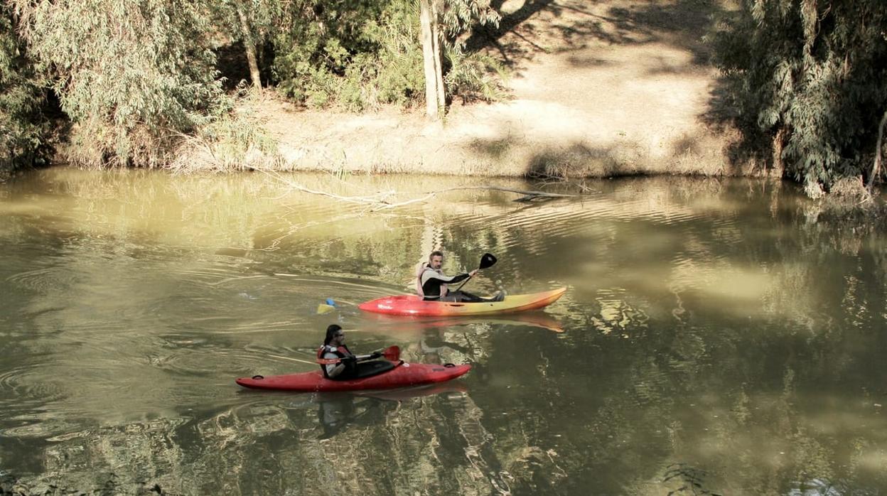 Dos de los expedicionarios en su recorrido en barca por el río Guadaíra