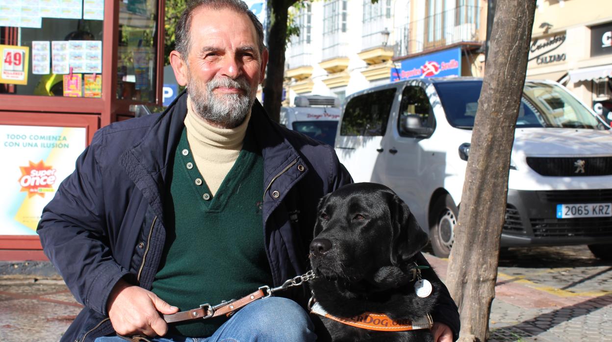 El utrerano Ricardo Fernández junto a su perro labrador que le sirve de guía