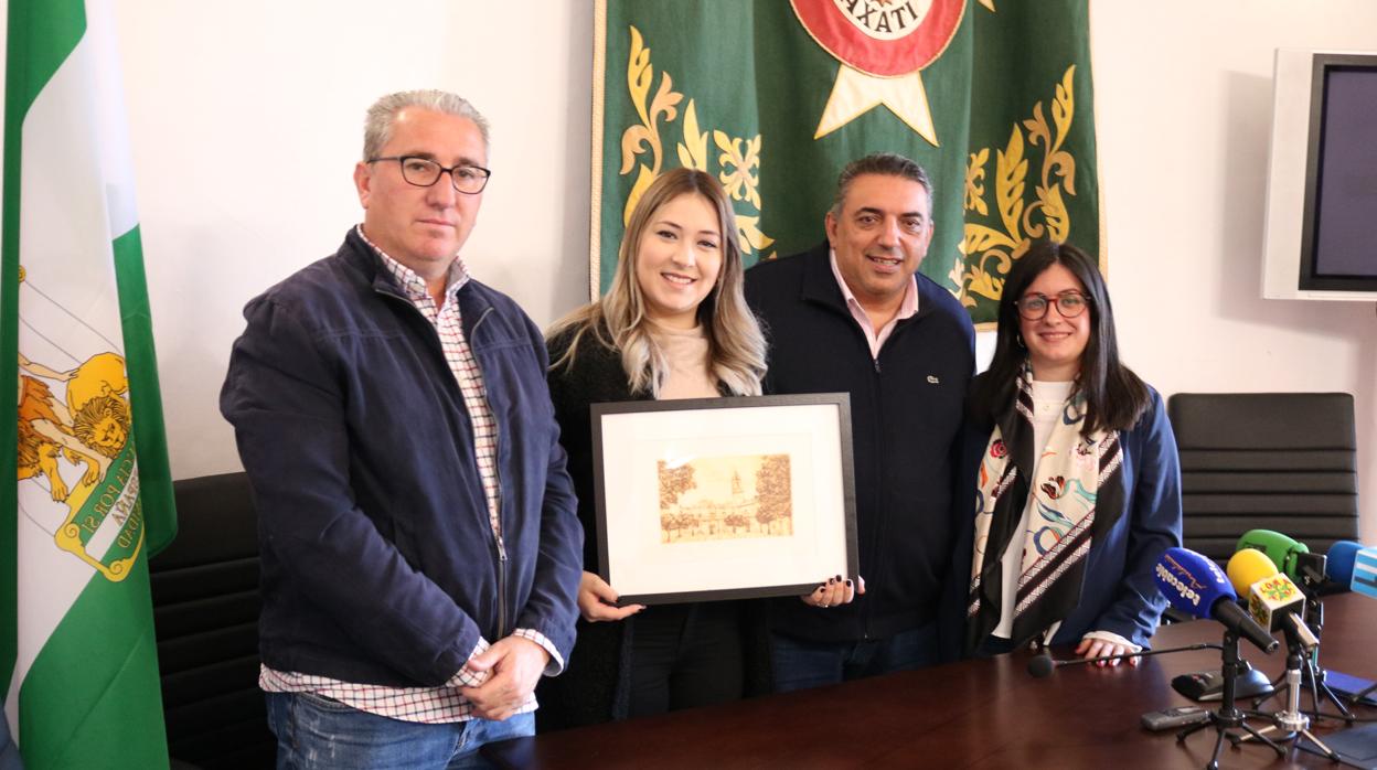 María Espinosa recibió como obsequio un cuadro con la fachada del Ayuntamiento de Lora del Río.