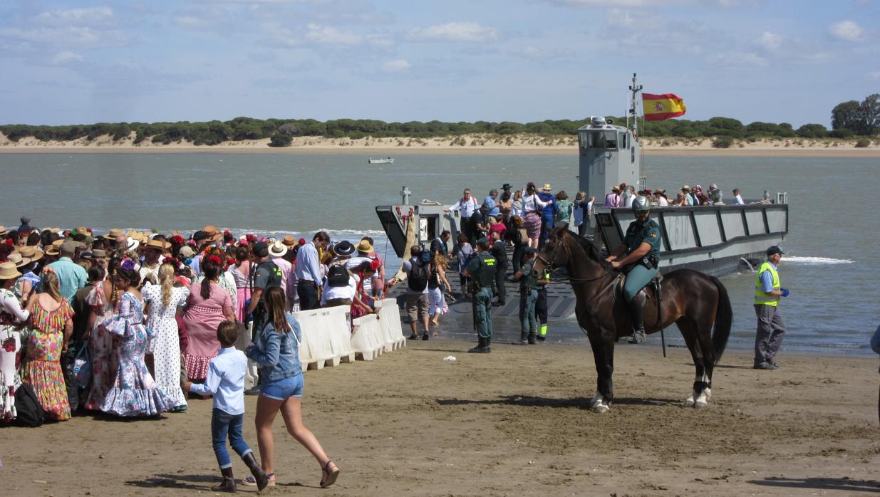 Los romeros embarcando en las lanchas de la Armada.