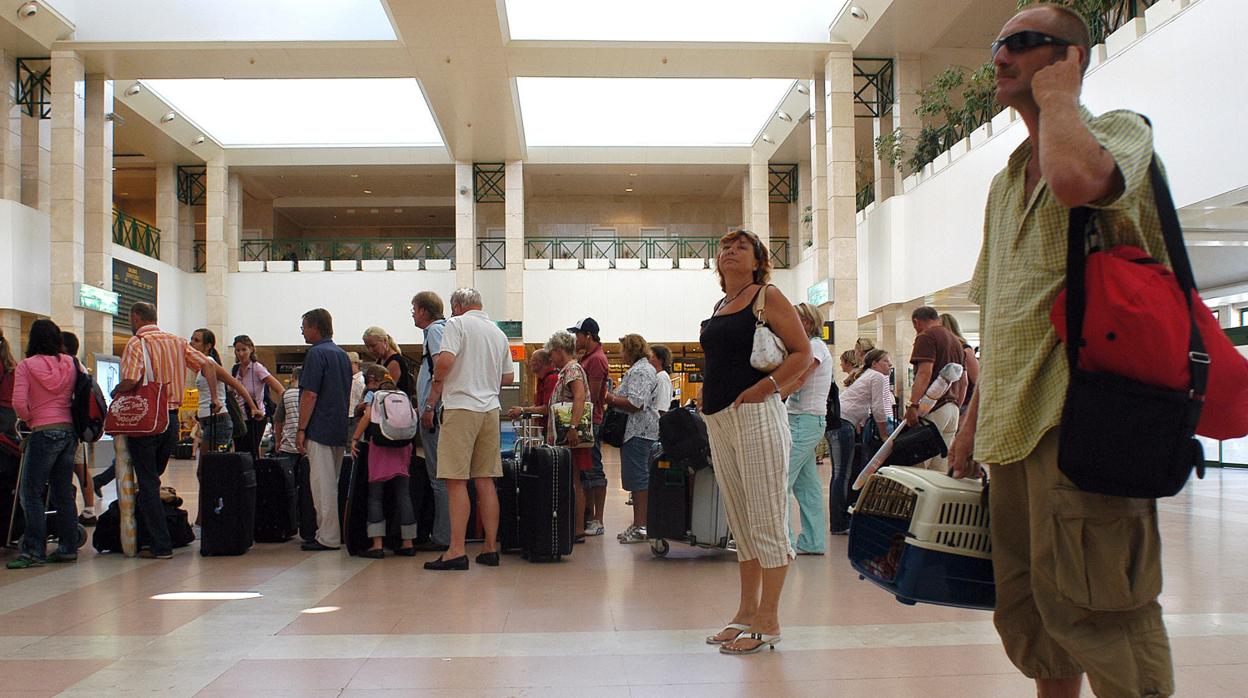 Turistas esperando para facturar sus maletas en el aeropuerto de Jerez.
