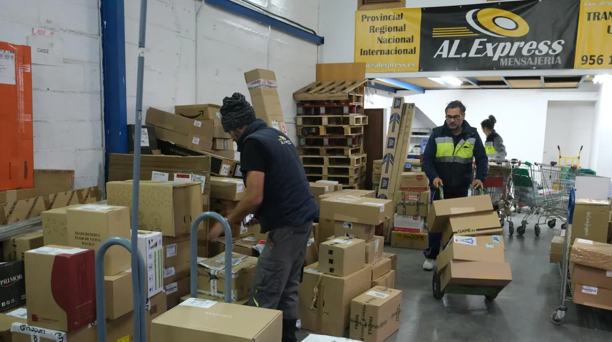 Trabajadores de una de las empresas de reparto con sede en la Zona Franca cargan cajas con regalos para esta Navidad.